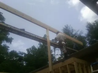 Carpenter setting a ridge beam over a new addition frame — Ice Dam Removal by Roofing Brothers in Blaine