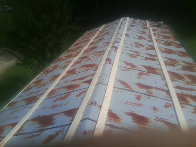 Rusted metal roof panels with new wood purlins before replacement — Storm Damage Roof Repair in Blaine by Roofing Brothers